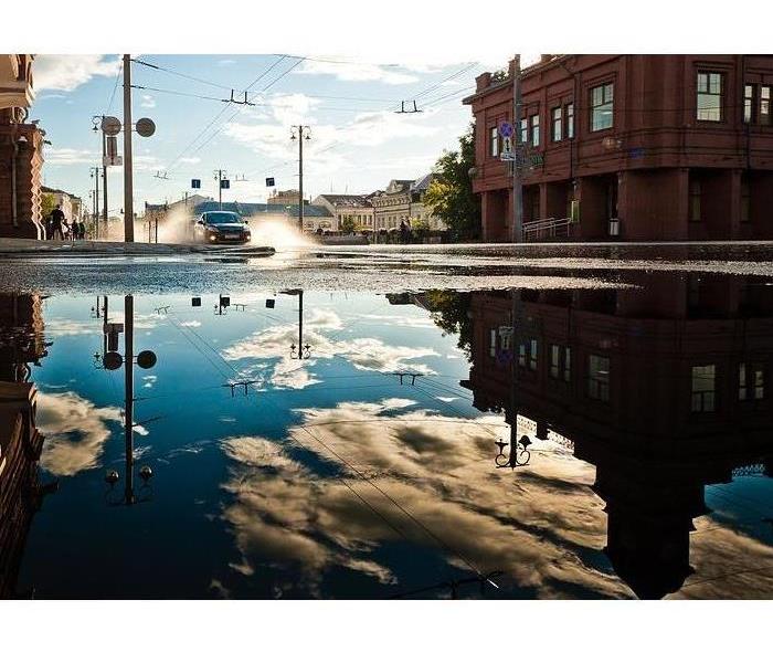 building reflected in flood waters on street