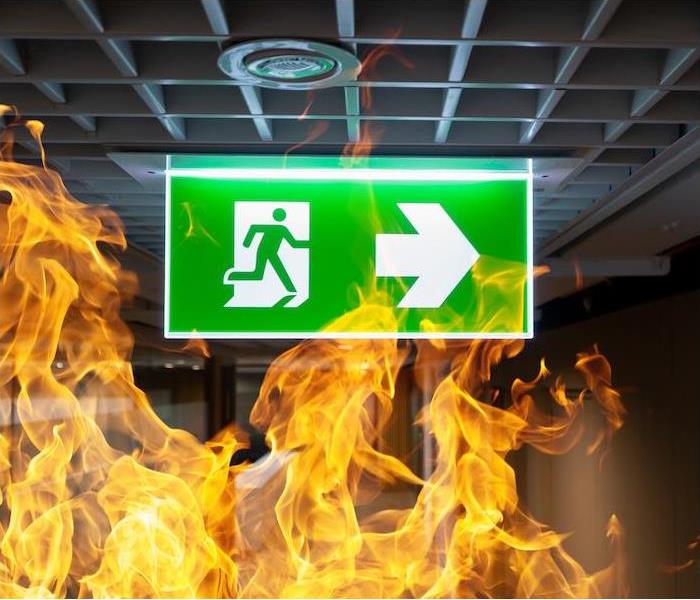 a green exit sign surrounded by flames